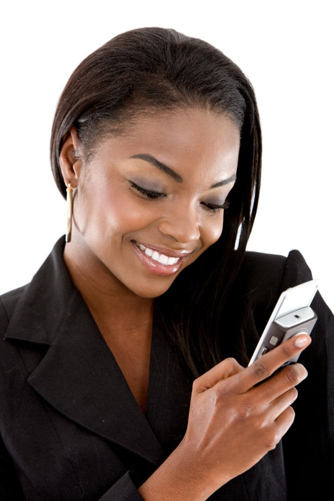 Business woman sending a text message on her mobile phone - isolated over a white background