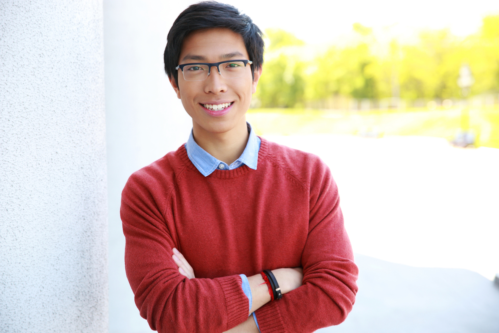 Portrait of happy asian man with arms folded