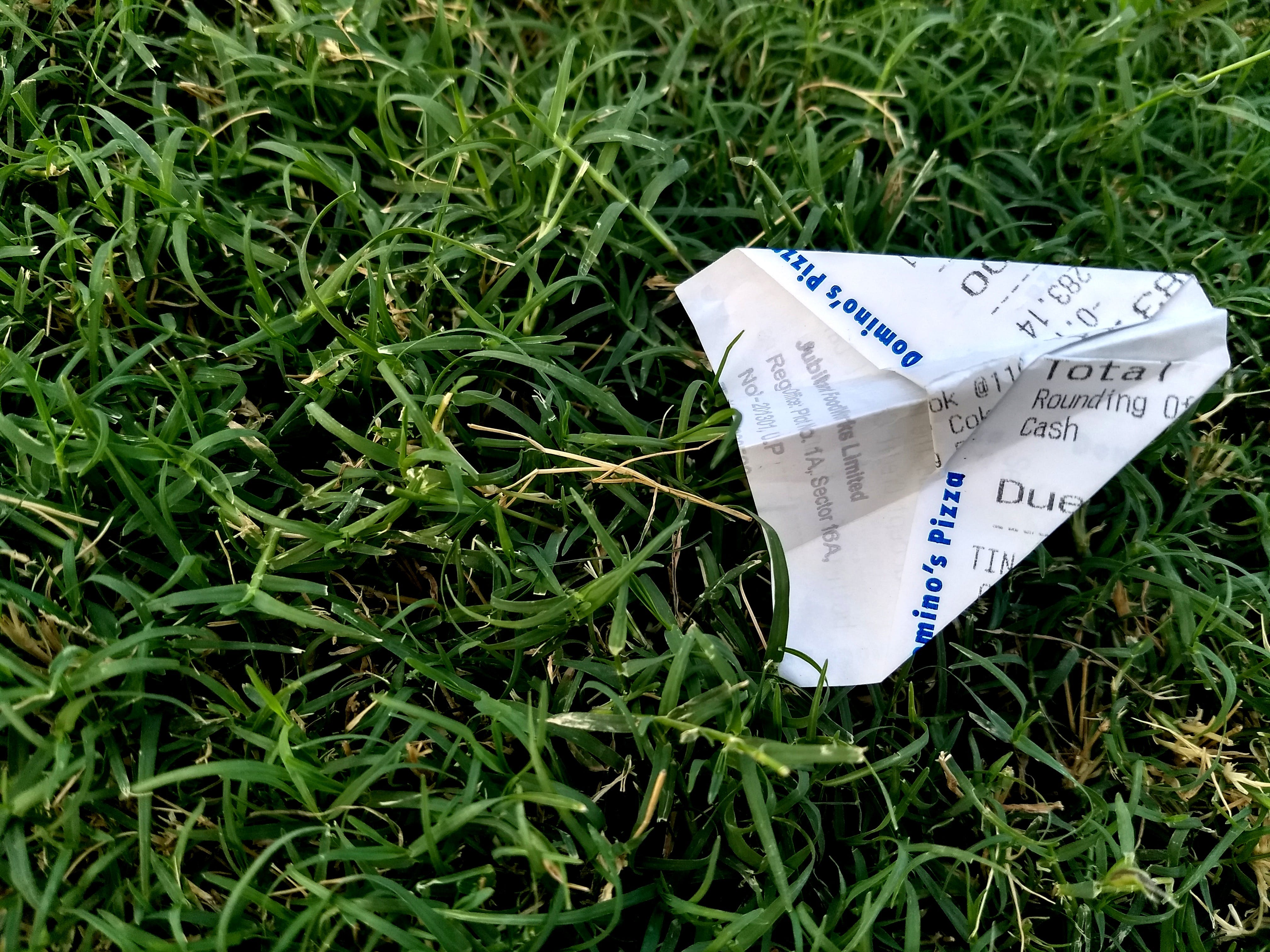 A folded up receipt made into a paper airplane, signifying paperwork panic